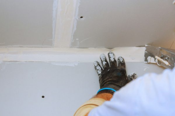 house-improvements-putting-plaster-on-the-wall-with-spatula-hand-holding-plastering-tool.jpg