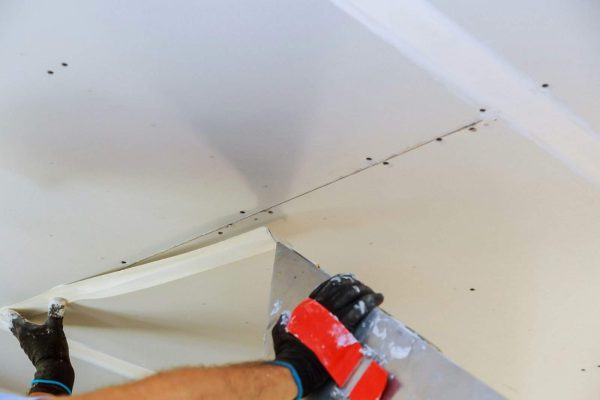 male-builder-repairs-wall-with-a-spatula-plaster-on-a-wall-e1708602454880.jpg