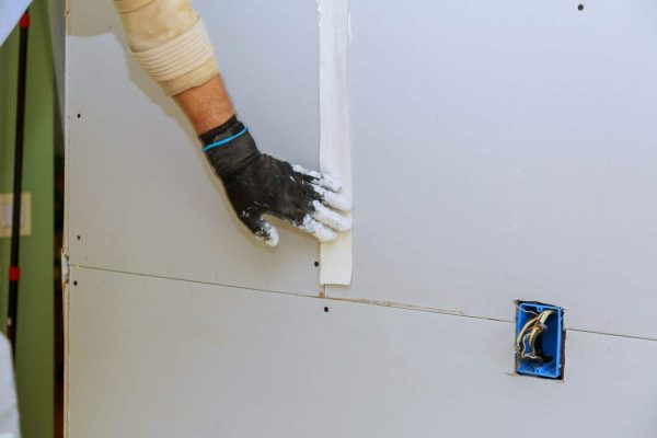 man-installing-gypsum-plasterboard-construction-with-drywall-installed-e1708603269762.jpg