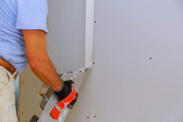worker-working-with-putty-and-spatula-work-aligns-with-wall-e1708602379332.jpg